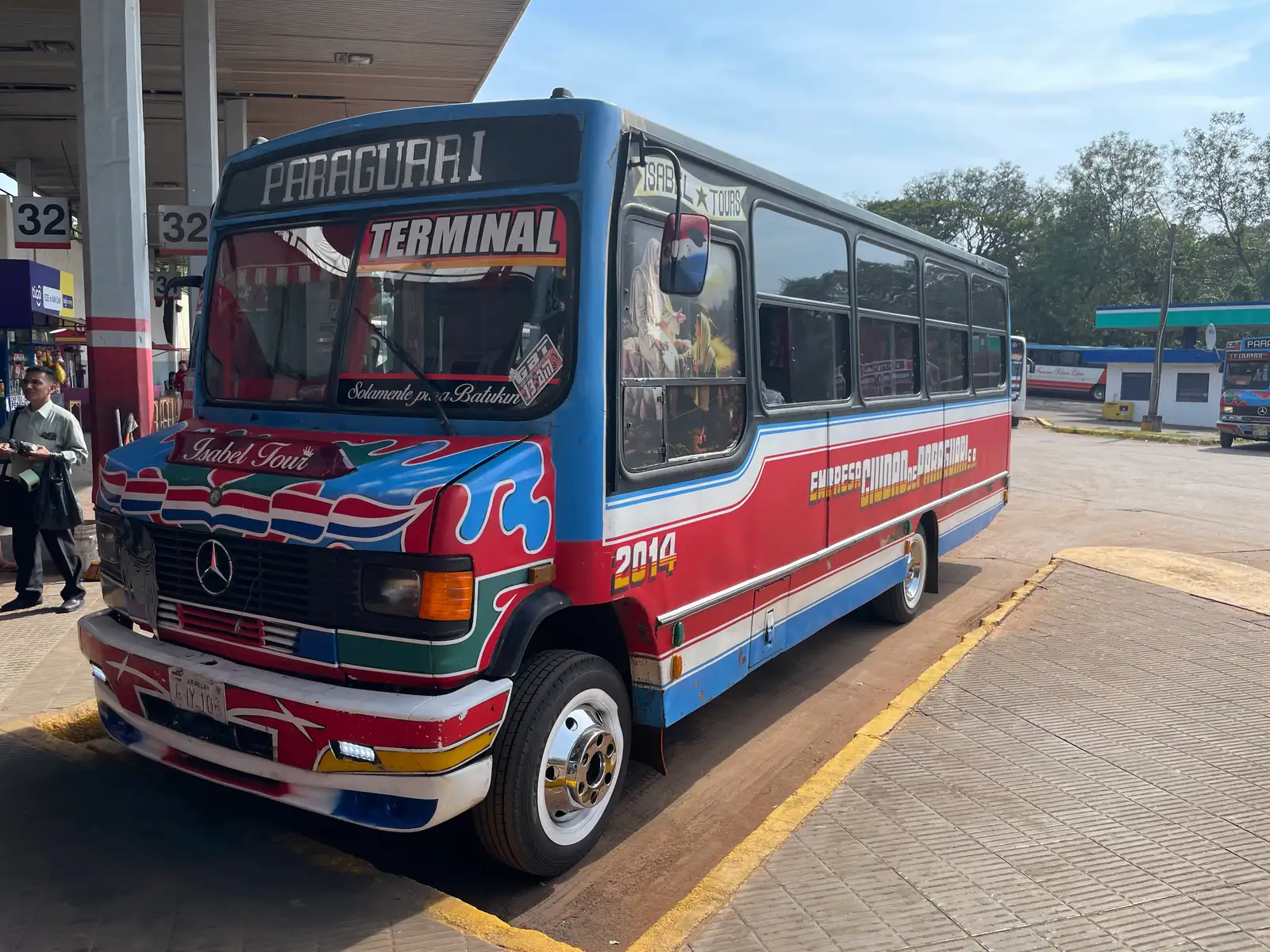 Ônibus intermunicipal colorido aguardando passageiros na rodoviária de Assunção, ponto de partida do transporte para o interior do Paraguai
